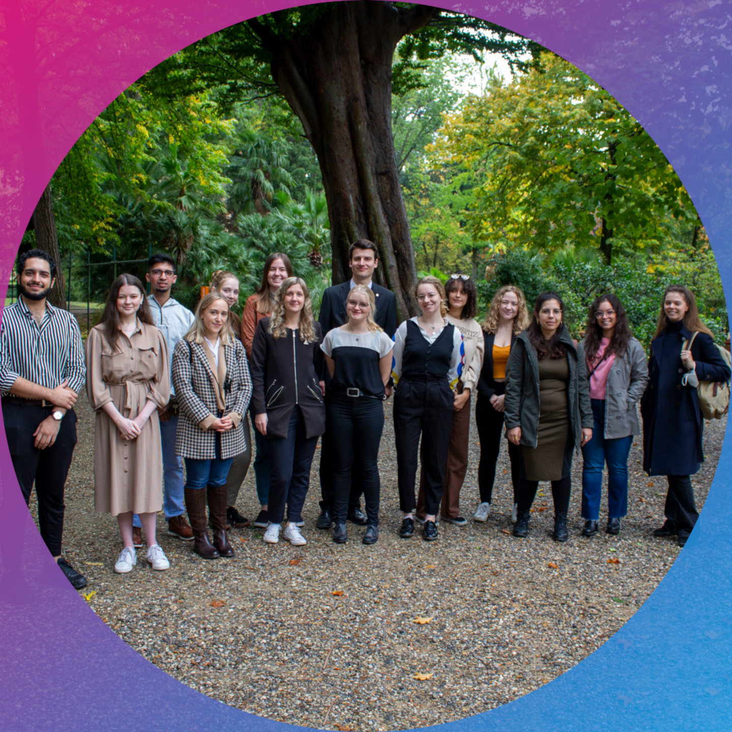 The photo shows a group of students smiling at the camera. In the background are plants. The picture is bordered by a circular frame in a colour gradient from magenta to cyan.